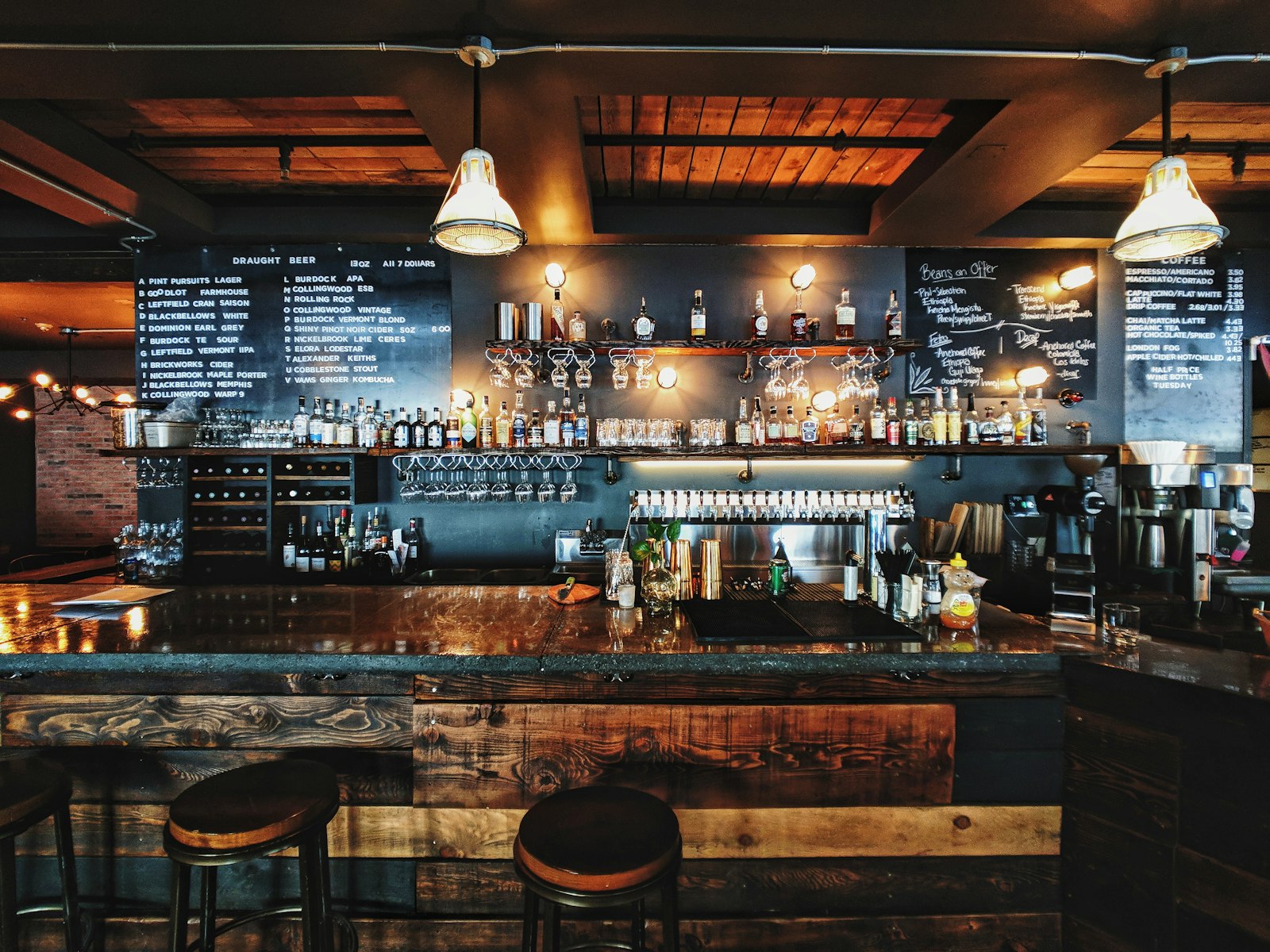 Bar z butelkami na półkach i wysokimi stołkami